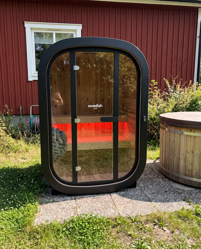 Private Escape placerad vid ett rött hus i en trädgård